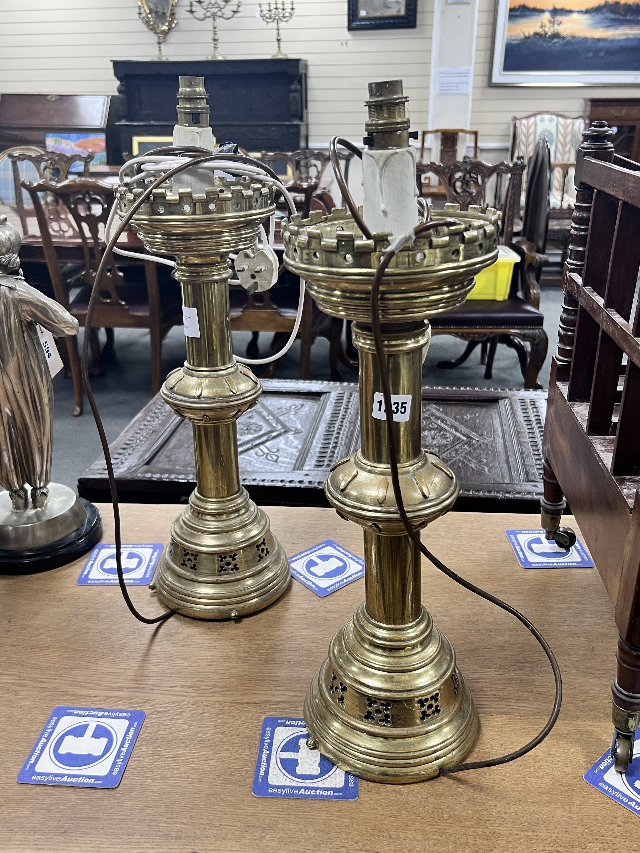 A pair of ecclesiastical style brass candlesticks converted to electricity, height 48cm